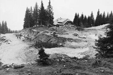 Historical picture of the construction of the Villach Alpine Road with machines and untravelled road | © villacher-alpenstrasse.at/Archiv