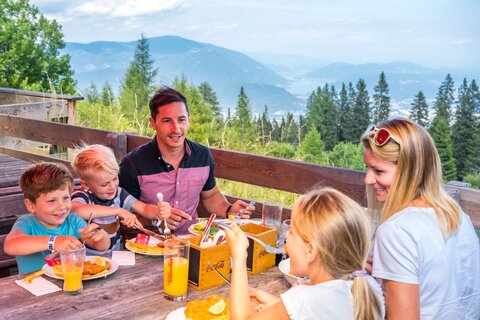 Family eating at the Villach Alpine Road | © villacher-alpenstrasse.at/Stabentheiner